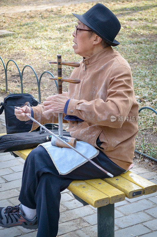 一位老人在天坛弹奏中国传统乐器