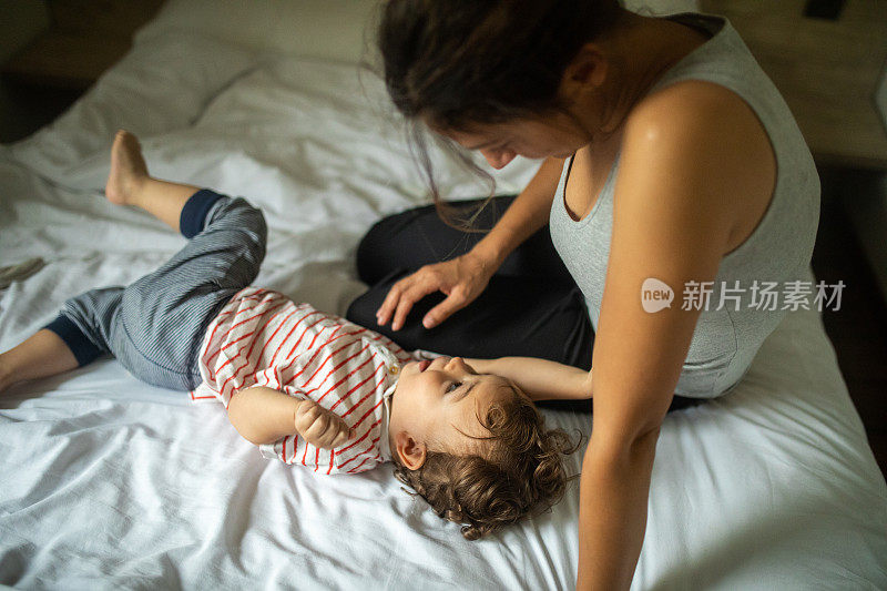 母亲和儿子享受时间一起在床上清晨