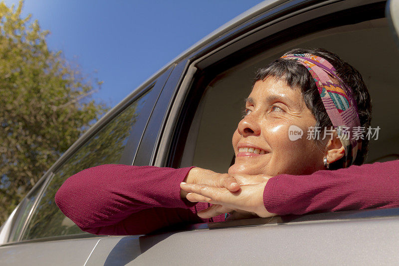 美丽成熟的女人享受阳光和他的车