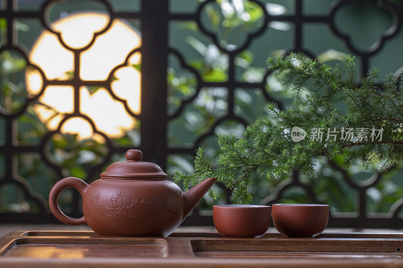 月光下窗花旁桌上的中国茶壶和茶杯