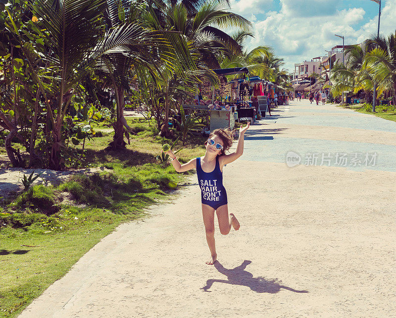 在墨西哥度假时，孩子在空旷的海滩大道上蹦蹦跳跳