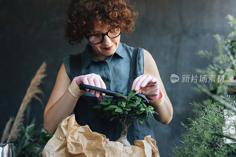 微笑的女人园丁照顾盆景树