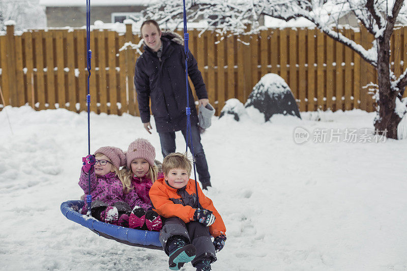 父母带着3个孩子在外面玩冬天的雪