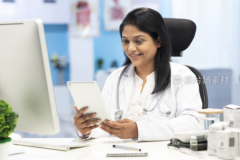 中年女性医生使用数字平板电脑在诊所，库存照片