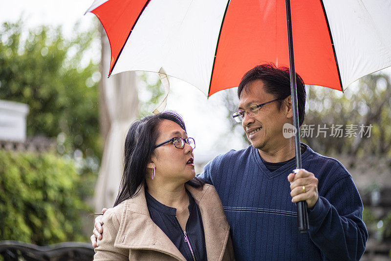 雨中撑伞的亚洲情侣