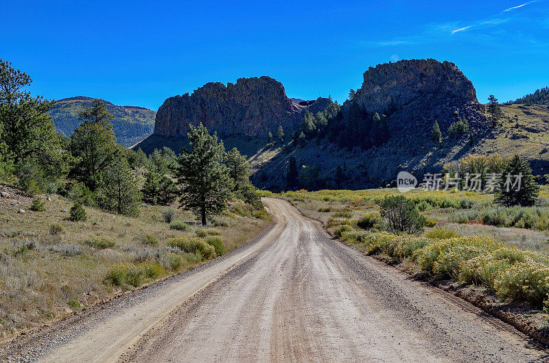 偏僻的乡村土路通过崎岖的西部景观与山岗附近的Ridgeway