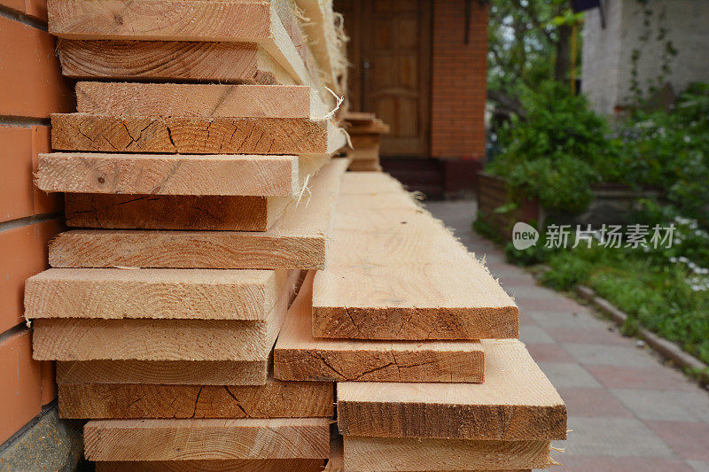 木制建筑材料:房屋装修期间储存在房屋附近的木板、厚木板和锯材。木材堆栈。