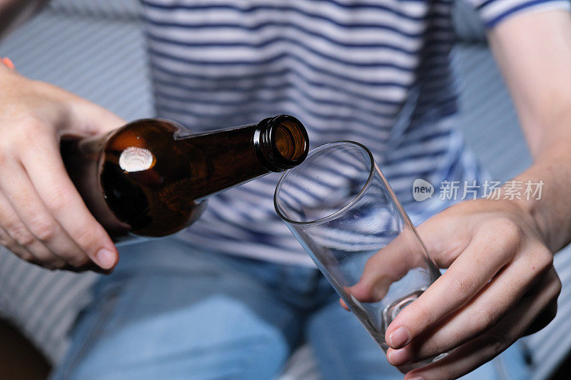 坐在沙发上的人正在喝啤酒