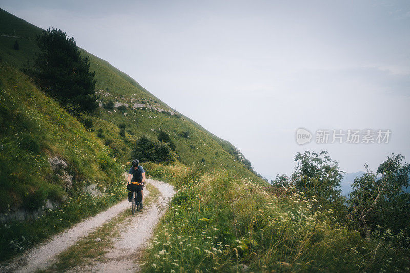 年轻人沿山路骑自行车的景象