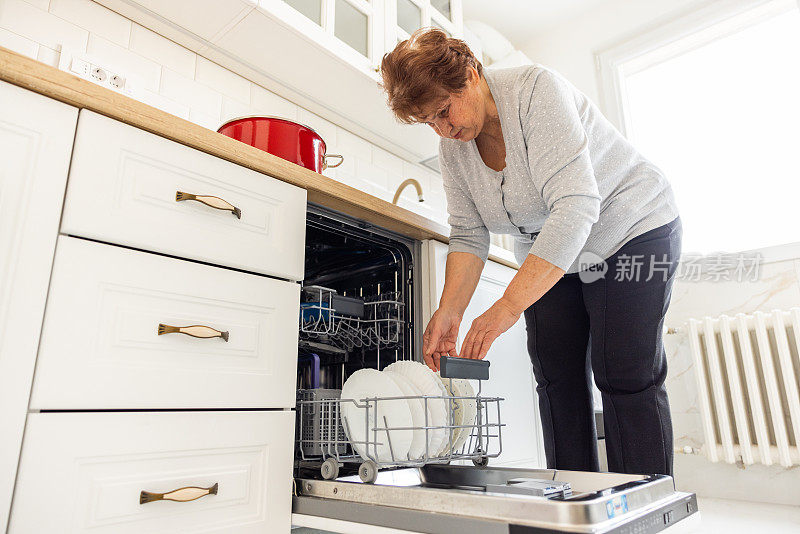 高级女性在装洗碗机