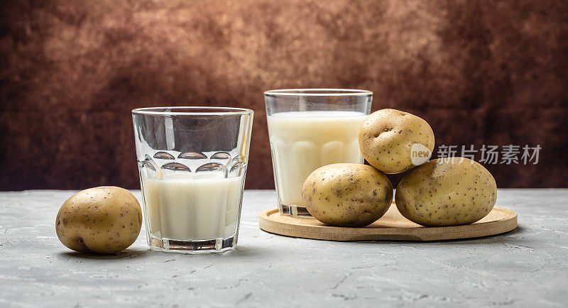 玻璃素食土豆奶和生土豆。替代植物奶。超级食品的概念。健康,干净的吃。素食或无麸质饮食。横幅，菜单，食谱文本的地方