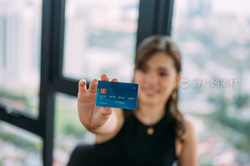 年轻漂亮的亚洲女性购物者持有信用卡