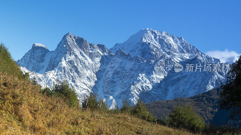 为明信片设计或屏幕保护程序从空中观看雪山山脊。山峰在阳光下为旅行主题