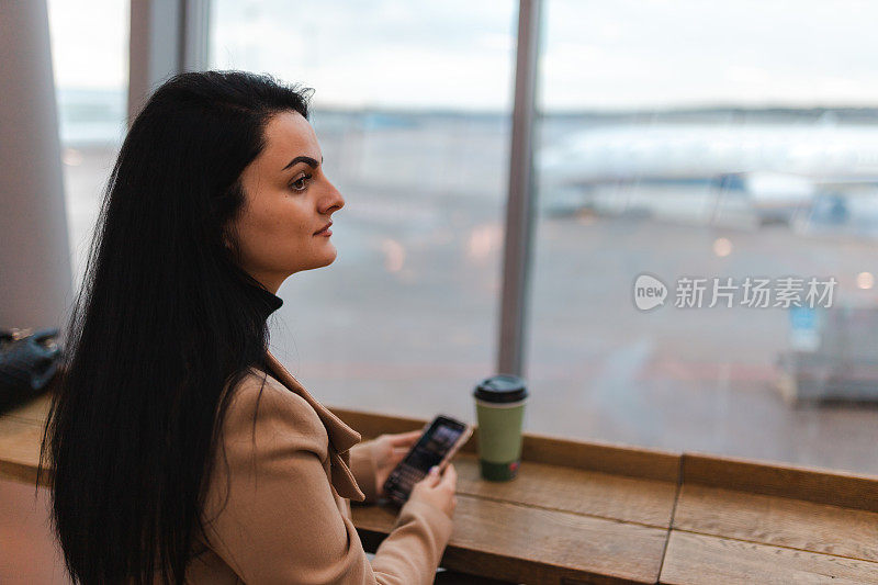 美丽的年轻女子在机场等待她的航班