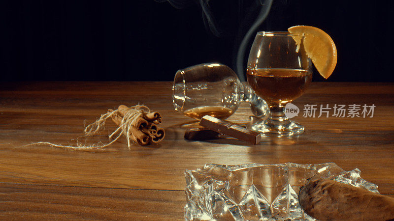 一杯干邑或白兰地，也可以是威士忌，再在烟灰缸上放一支雪茄