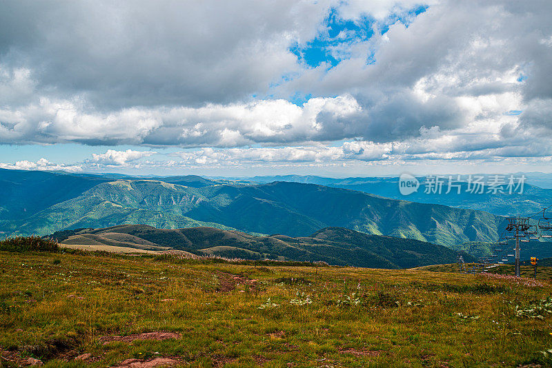 在一个阳光明媚的夏日里，有美丽的山峦和岩石景观。