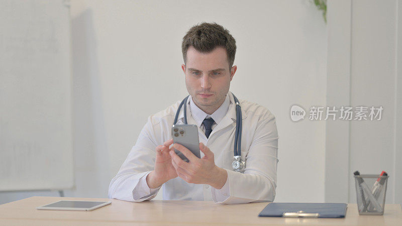年轻医生在诊所浏览智能手机