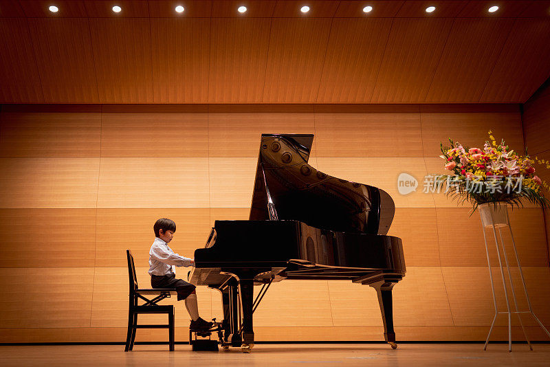 小男孩在音乐厅弹钢琴