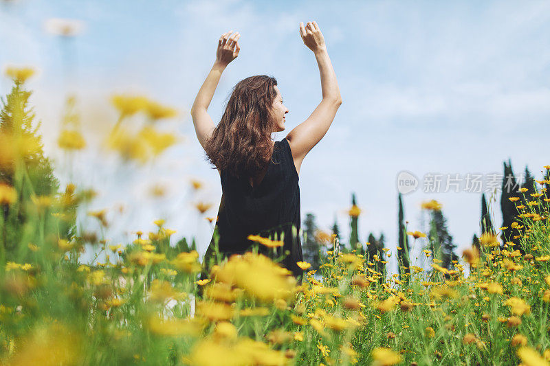 年轻女子在花圃里享受阳光