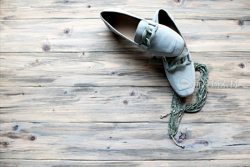 时尚的灰色皮革女子休闲鞋孤立的木制背景