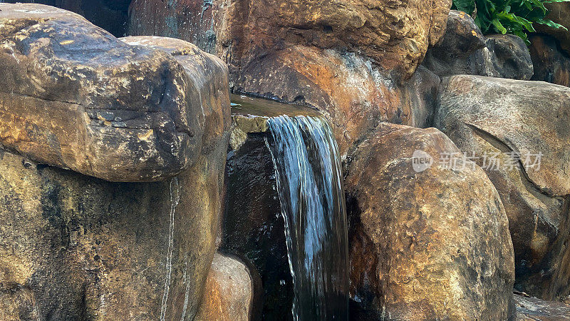 一个小瀑布在一个大的岩石装饰自然。