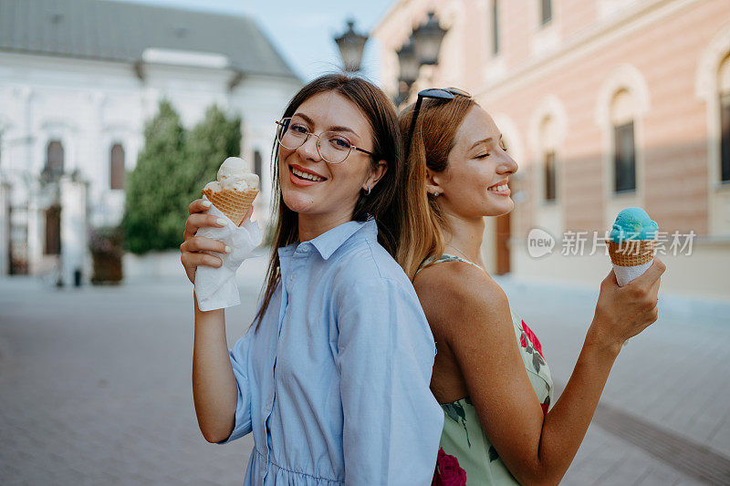 两个朋友在一个阳光明媚的日子里津津有味地吃着冰淇淋