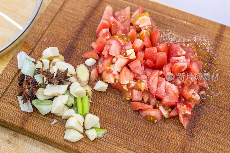 切碎的番茄，姜和大蒜放在砧板上
