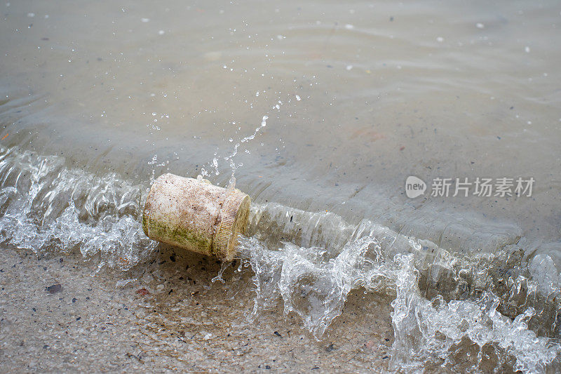 废弃的塑料容器被海浪冲到海滩上。