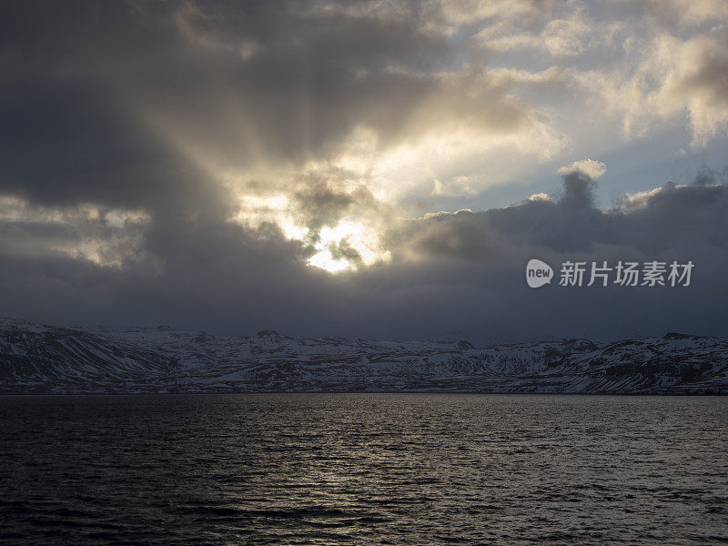 太阳穿过冰岛山脉上空的云层