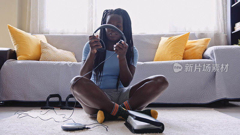 黑人女孩在家里用便携式CD播放器听音乐。音乐疗法。
