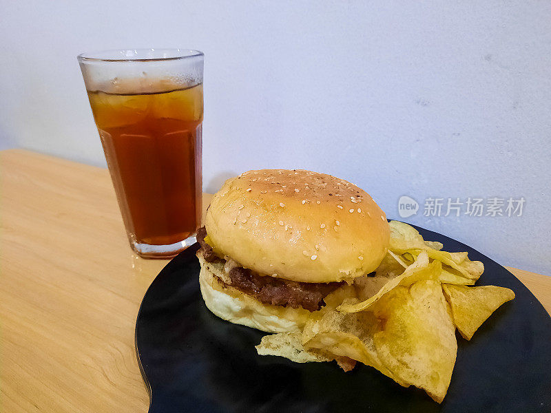 可口的安可汉堡配薯片和凉茶。食物和饮料菜单