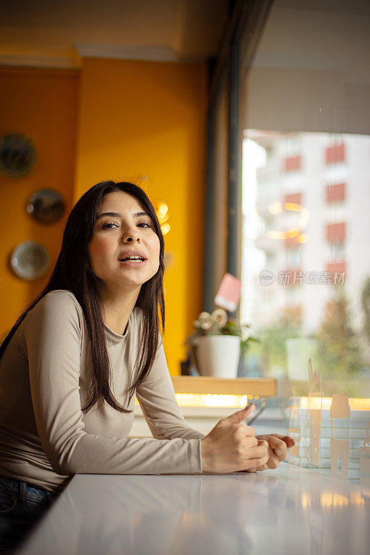 咖啡店里年轻黑发女人的肖像。