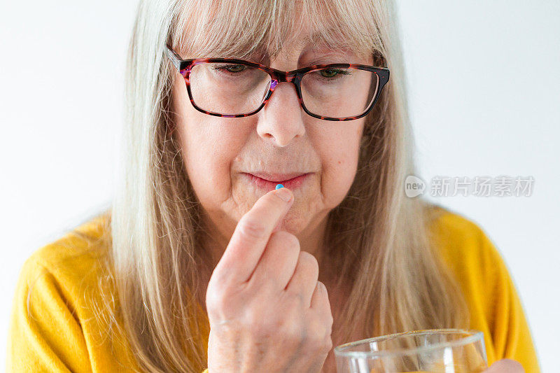 一位老年妇女正在服用药物