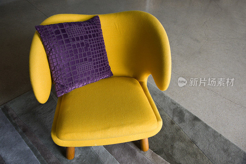 黄色的安乐椅和紫色的枕头