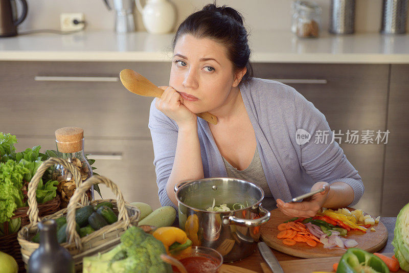 女人在厨房做饭(用智能手机)