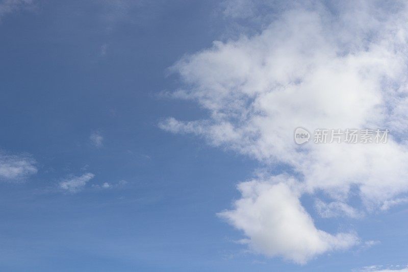 蓝色天空映衬着蓬松、缕缕白云的特写