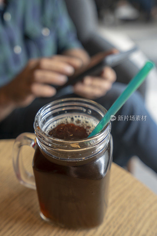 一个年轻人在咖啡店里冰咖啡杯的照片