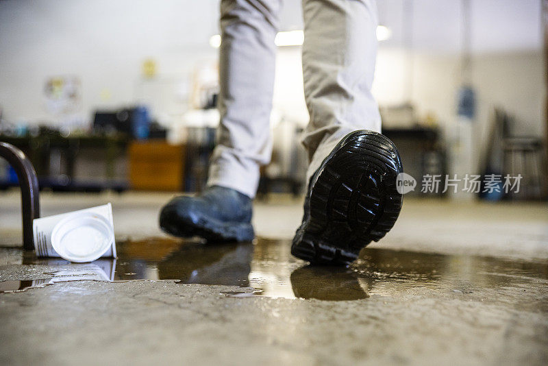 一名工人在仓库行走时溅出液体。
