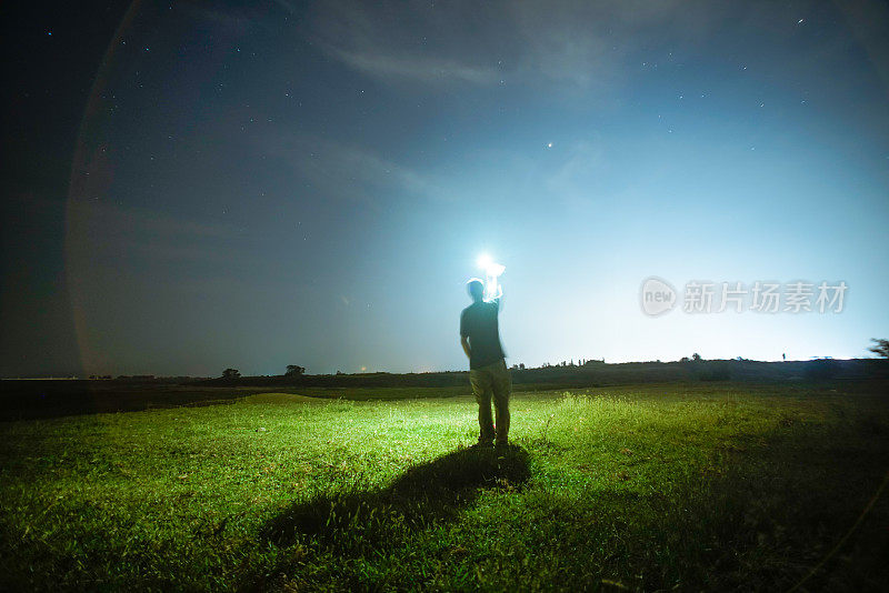 一个人站在夜空下的草地上