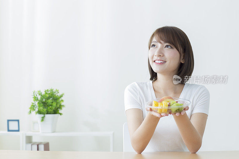 年轻女人拿着水果