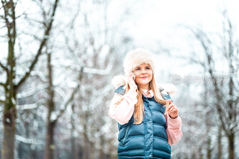 一个年轻女子在一个下雪的冬天打电话