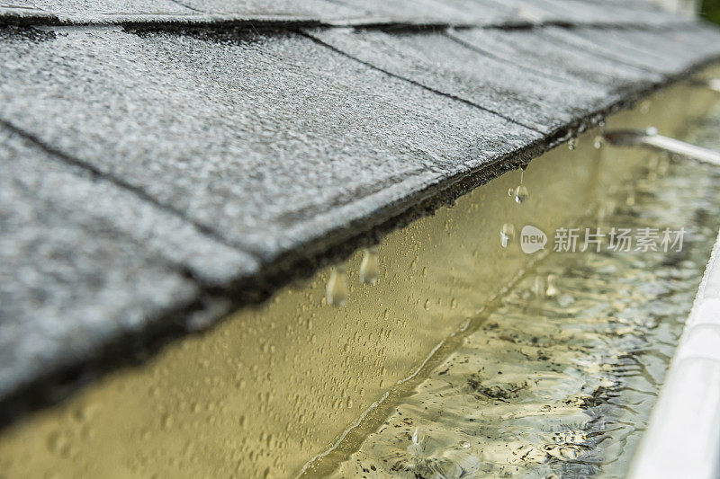 雨水从屋顶上的瓦片流入住宅的排水沟