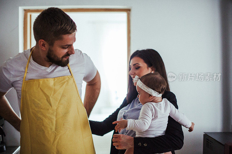 年轻的女商人兼厨师带着孩子在厨房里