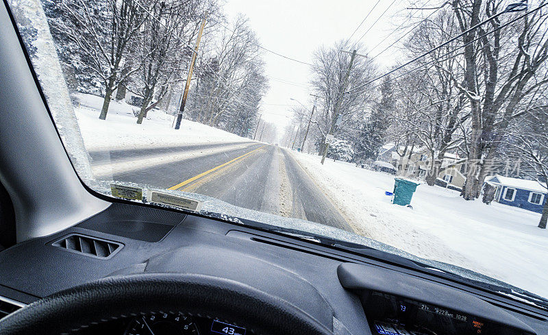 汽车在冬季暴风雪的乡村道路上行驶