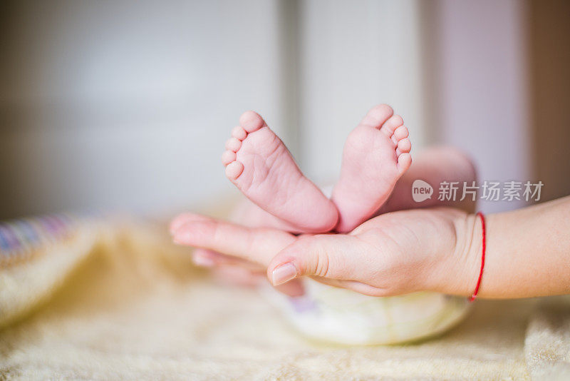 新生婴儿的脚在母亲的手中