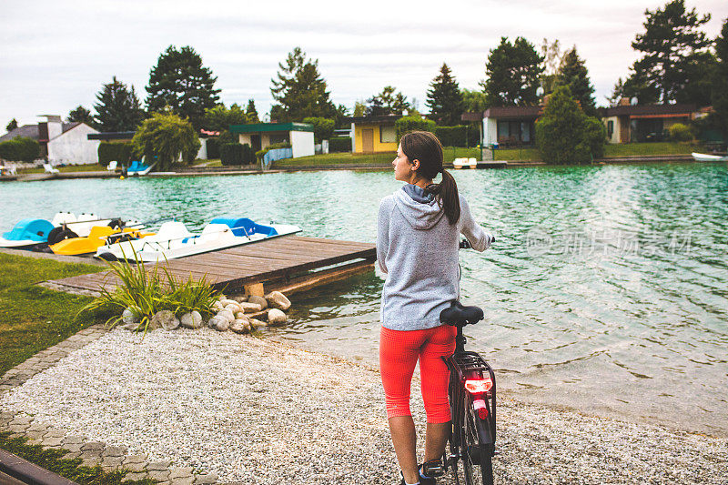 湖边骑着电动自行车的女人