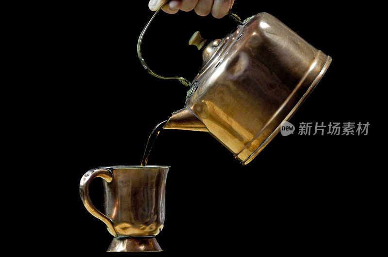 将茶倒入杯子的老式水壶