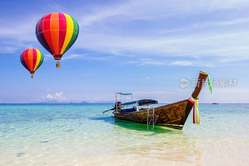 五颜六色的热气球飞过泰国甲米的海面。