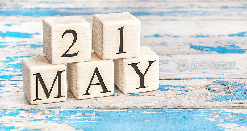 5月21日。木制立方体与日期5月21日在旧的蓝色木制背景。