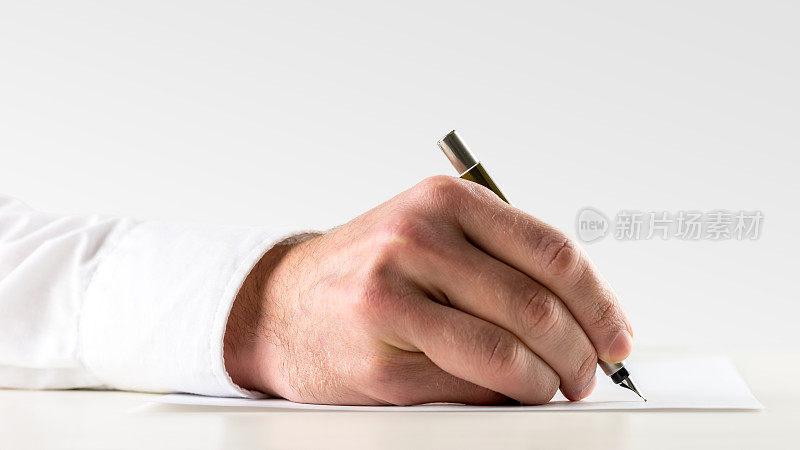 男人用钢笔在纸上写字